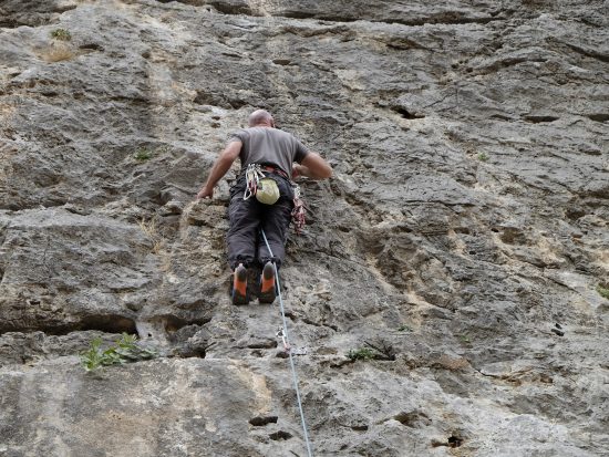 Climber has the rope behind his leg and risks falling upside down