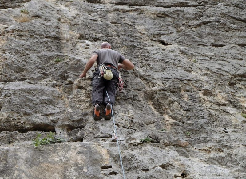 Climber has the rope behind his leg and risks falling upside down